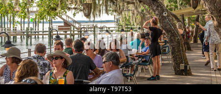 Sonnenuntergang Dinieren unter Florida live Eichen am Wasser deck an Caps auf dem Wasser, ein lokales Seafood Restaurant am Intracoastal in St. Augustine, FL Stockfoto