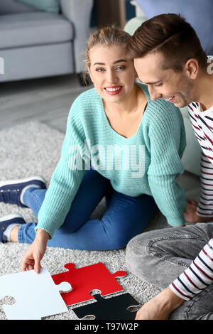 Junges Paar Montage Puzzle auf dem Boden zu Hause Stockfoto