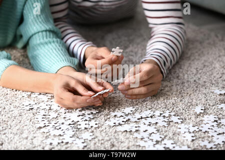 Junges Paar Montage Puzzle auf dem Boden zu Hause Stockfoto