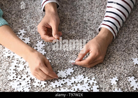 Junges Paar Montage Puzzle auf dem Boden zu Hause Stockfoto