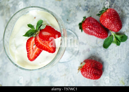 Eis mit Erdbeeren in einem Glas Vase. Grau strukturierten Hintergrund. Nachtisch. Lebensmittelkette Stockfoto