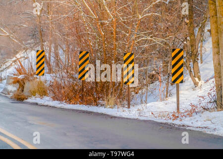 Mountain Road und Verkehrszeichen im Winter gesehen Stockfoto