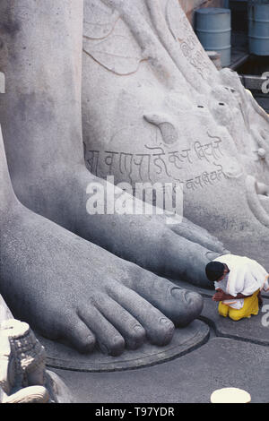 Priester, die Puja am Fuß der Bahubali Statue, SRAVANBELGOLA, Karnataka Stockfoto