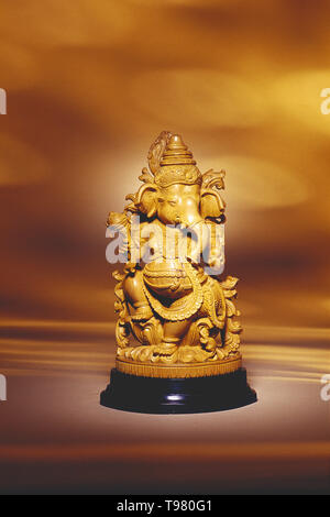 Noch immer LEBEN EINES GANESH IDOL AUS SANDELHOLZ GEGEN EINEN EINFACHEN HINTERGRUND Stockfoto