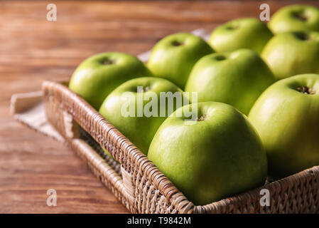 Leckere Äpfel im Korb Tablett auf hölzernen Tisch Reif Stockfoto