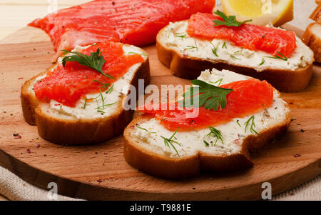 Sandwich mit roten Fischen auf einer hölzernen Schneidebrett Stockfoto