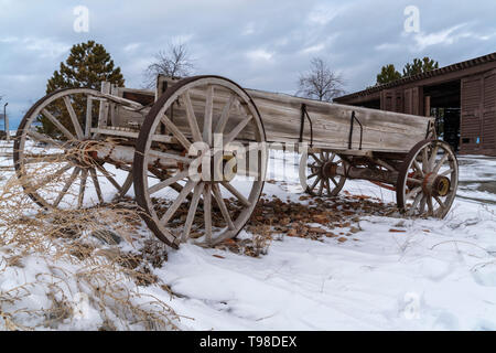 Einer Alten hölzernen Wagen auf einem felsigen Gelände mit Schnee im Winter abgedeckt Stockfoto