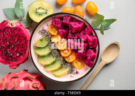 Joghurt mit verschiedenen Früchten in Schüssel auf hellen Hintergrund Stockfoto