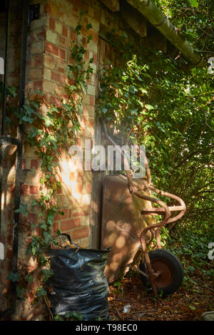 Moody abstract von gardners Schubkarre in dappled Licht auf dem Gelände des St. Laurance, Henley-in-arden, Alcester, Warwickshire Stockfoto