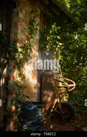 Moody abstract von gardners Schubkarre in dappled Licht auf dem Gelände des St. Laurance, Henley-in-arden, Alcester, Warwickshire Stockfoto