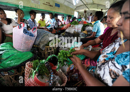 02.09.2013, Yangon, Myanmar - Passagiere sitzen zwischen den Waren, die in einem Zugabteil des kreisförmigen Bahn. Die lokale S-Bahn Netz Stockfoto