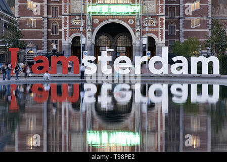 Atemberaubende Landschaft Bild des Rijksmuseum und das Spiegelbild im Wasser mit der iamsterdam signage vor dem Museum Stockfoto