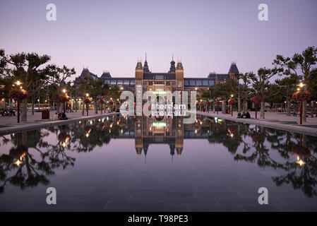 Atemberaubende Landschaft Bild des Rijksmuseum und das Spiegelbild im Wasser mit der iamsterdam signage vor dem Museum Stockfoto