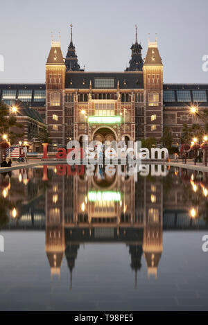 Atemberaubende Landschaft Bild des Rijksmuseum und das Spiegelbild im Wasser mit der iamsterdam signage vor dem Museum Stockfoto