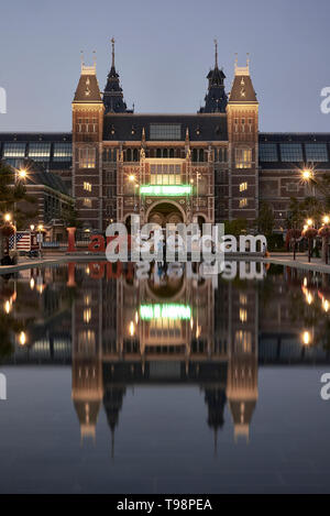 Atemberaubende Landschaft Bild des Rijksmuseum und das Spiegelbild im Wasser mit der iamsterdam signage vor dem Museum Stockfoto