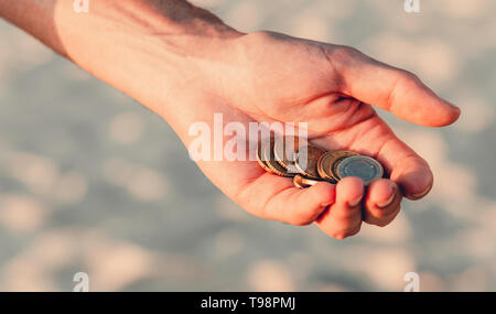 Eine Handvoll Münzen auf einem grauen Hintergrund, der Männer Palmen Euro halten, eine Menge Geld, wirtschaftliche Kosten, Armut Stockfoto