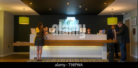 Lady tourist Einchecken in London Holiday Inn Rezeption, London, England, UK. Stockfoto