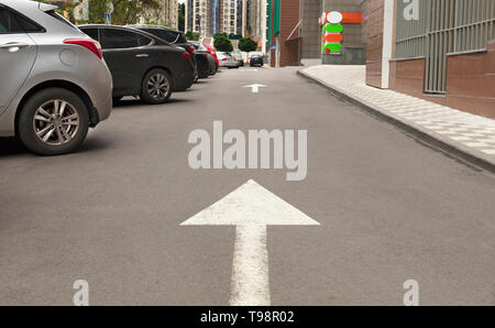 Signalisieren, Pfeil auf dem Asphalt zeigt die Richtung für das Fahren von Fahrzeugen in der Nähe der lokalen Stockfoto