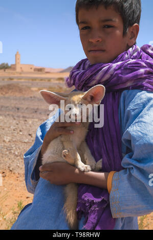 Porträt eines Jungen mit eared Fuchs in seine Hände in den nationalen Berber Kleidung. Stockfoto