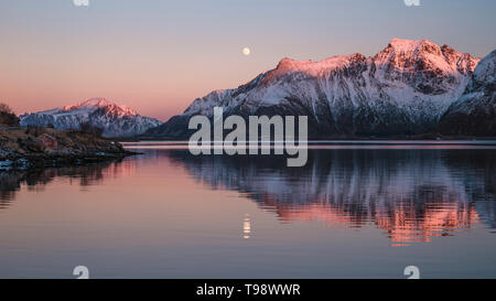 Bergspitzen im Abend Licht reflektieren Zusammen mit dem Vollmond im Wasser, Lofoten, Nordland, Norwegen Stockfoto