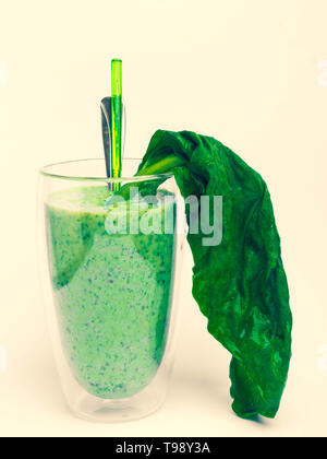 Gesunden grünen Smoothie mit Grünkohl Spinat Kiwi in einem Glas auf gelbem Hintergrund Stockfoto