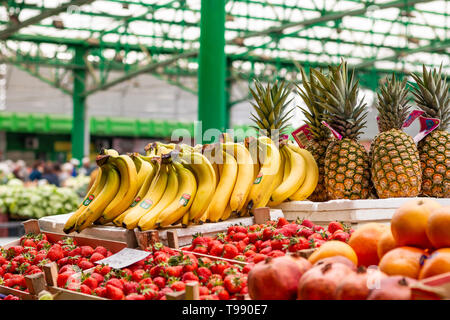 Frischen bunten Obst in hölzerne Körbe bereit für den Verkauf auf dem Markt in Belgrad. Ananas und Bananen. Stockfoto