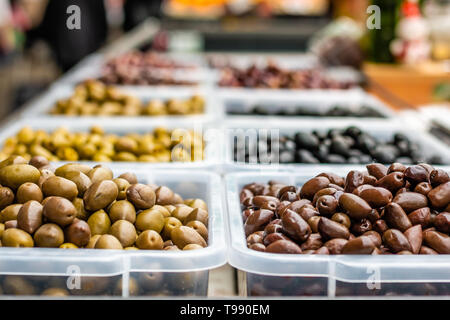 Sortiment von Oliven auf dem Markt. Reihen von verschiedenen Arten von Oliven in transparentem Kunststoff Schalen. Stockfoto