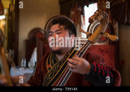 Mongole spielt Instrument im Speisewagen, Transsibirische Eisenbahn, Bügeleisen Stockfoto