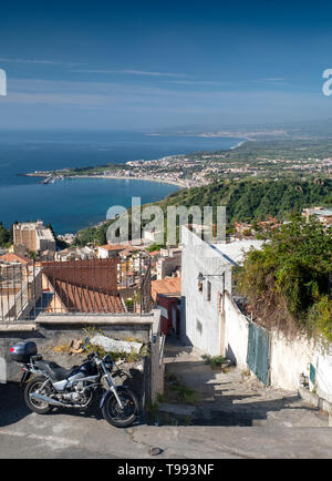 Blick über die Dächer auf die Bucht von Naxos, Taormina, Sizilien. Stockfoto