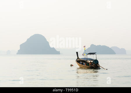 Long Tail hölzerne Boote am Klong Muang Beach bei Sonnenuntergang in der Provinz Krabi, Thailand. Stockfoto