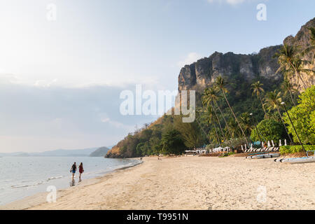 Junges Paar zu Fuß auf Pai Plong Strand bei Sonnenuntergang in der Provinz Krabi, Thailand. Stockfoto