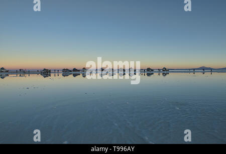 Jeeps aufgereiht bei Sonnenuntergang auf dem Salzsee der Salar de Uyuni, Bolivien Stockfoto