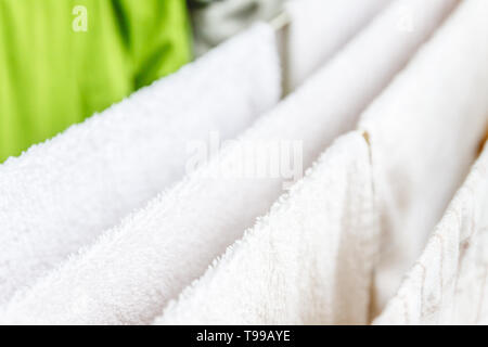 Weiße und farbige Bettwäsche und Handtücher auf der Wäscheleine getrocknet werden. Stockfoto