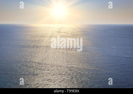 Die Sonne scheint und auf der Wasseroberfläche über dem Meer spiegeln Stockfoto