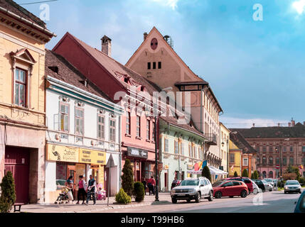 Alba Iulia, Rumänien - 9. April 2019: Street View von Sighisoara an einem sonnigen Tag mit Menschen bummeln und viele Autos geparkt. Stockfoto