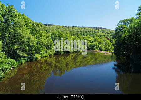 Großbritannien, Derbyshire, Peak District, Calver, River Derwent und Curbar Edge von New Bridge. Stockfoto