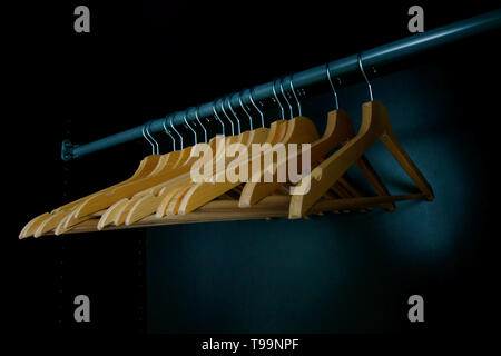 Leere Kleiderbügel aus Holz auf einem Schrank Schiene, Konzept für teure saisonale Kleidung Wunsch und 'nichts zu tragen" oder Etikett - besessen Verbraucher Stockfoto