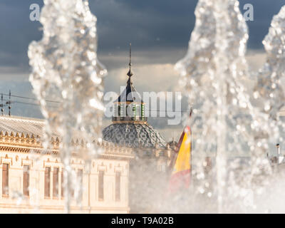 Spanische Flagge und öffentliche Gebäude hinter der Brunnen, Basilika de San Juan De Dios im Hintergrund Stockfoto