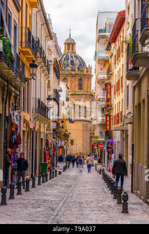 Farbe voll Straße von Granada, Menschen zu Fuß. Iglesia de los Santos justo y Pastor im Hintergrund. Stockfoto