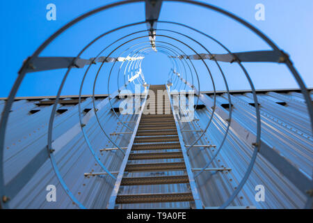 Vertikale metall Treppe zum Dach des Hangar. Treppe von einer schützenden Rahmen umgeben. Stockfoto