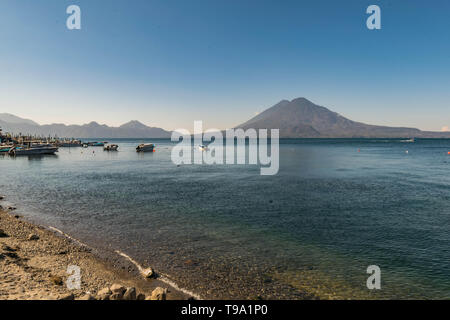 Atitlan See, Ufer, Boote und Vulkan im Hintergrund, in Panajachel, Guatemala Stockfoto