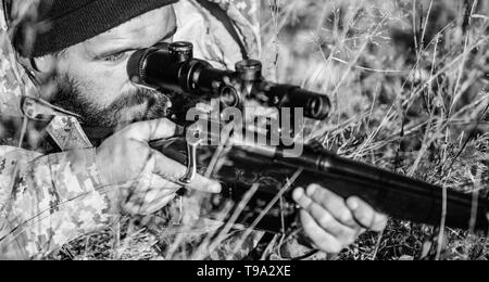 Mann Jäger mit Gewehr Pistole. Boot Camp. Bärtiger Mann Jäger. Die Streitkräfte. Camouflage. Uniform Mode. Jagd Fähigkeiten und Waffen Ausrüstung. Wie schalten Sie die Jagd in Hobby. Strenge Urteil. Stockfoto