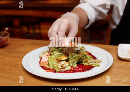 Koch ist mit pflanzlichen Appetizer auf weißem Porzellan Platte Stockfoto