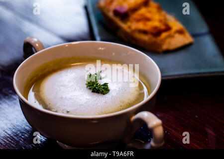 Nahaufnahme der Pilzsuppe in weißer Keramik Schale auf Tischplatte Frühstück gesunde Idee. Stockfoto