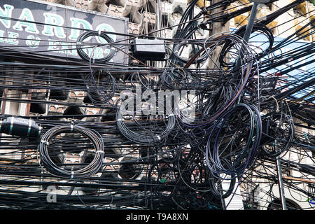 BANGKOK, THAILAND, 9. JANUAR 2019 - Chaos der Kabel und Leitungen auf einem elektrischen Pol. Viele elektrische Kabel - Kabel und Telefonleitung auf Strom pos Stockfoto