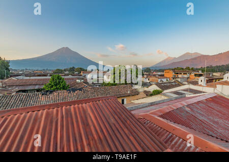 Blick über Dächer mit Vulkane in der Ferne, in Antigua, Guatemala Stockfoto