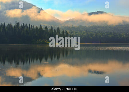 Nebel und Reflexion über Lac La Joie bei Sonnenaufgang Parc National du Mont Tremblant Quebec Kanada Stockfoto