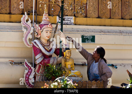 Eine Frau, die Baden des Buddha Ritual, Bago. Myanmar, Dezember 2011. Stockfoto