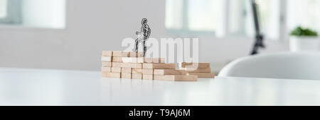 In der breiten Ansicht Bild von Hand gezeichnete Silhouette der Geschäftsmann, klettern die Schritte aus Holz auf einem Büro Schreibtisch. Stockfoto