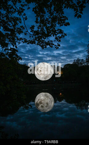 Brighton UK 17. Apr 2019 - Massen um Queens Park Teich in Brighton versammelten sich an diesem Abend das Brighton Festival Veranstaltung 'Museum der Mond' des Künstlers Luke Jerram, die zum 50. Jahrestag der Mondlandung gefeiert zu beobachten. Der Mond beleuchtet, über das Wochenende werden, begleitet von Musik des Komponisten Dan Jones. Foto: Simon Dack/Alamy leben Nachrichten Stockfoto
